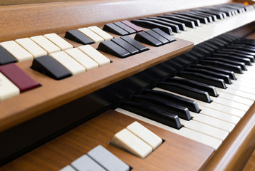 Closeup of the knobs and keyboard of an old electric organ