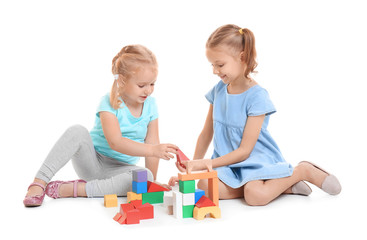 Obraz na płótnie Canvas Cute little girls playing with building blocks on white background