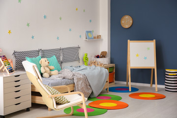 Modern child room interior with comfortable bed and armchair