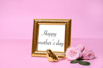Greeting card with phrase "HAPPY MOTHER'S DAY" in frame and flowers on color background