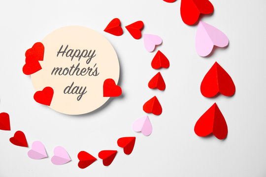 Greeting card with phrase "HAPPY MOTHER'S DAY" and paper hearts on white background