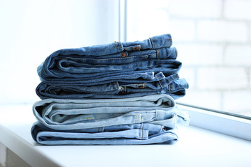 an ideal stack of jeans with a tag on the shelf of the store. a lot of folded jeans. jeans on the shelf. 