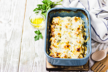 Turkey meatballs in cream sauce in baking dish on white wooden background. Selective focus, space for text.