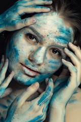 Beautiful model with creative makeup art. Caucasian girl with painted face in blue white flowers