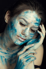 Beautiful model with creative makeup art. Caucasian girl with painted face in blue white flowers