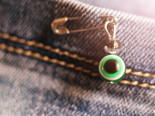 Evil eye on a pin on jeans