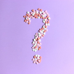 question mark laid out on a beautiful background of hearts. concept of choice. minimalism. creative. 