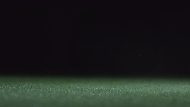 Closeup of soccer ball shoot by professional player on stadium field with artificial turf