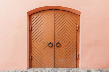 Ancient wooden door in the wall, brown. Texture