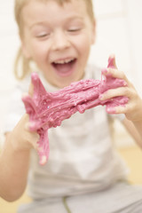 child playing hand made toy called slime. selective focus