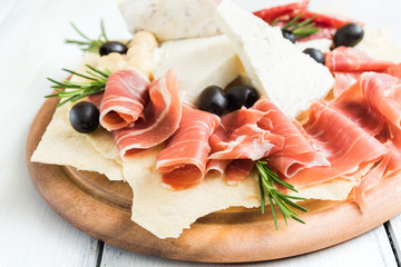 Tagliere con formaggio fresco, pane carasau, prosciutto crudo, salame e olive 