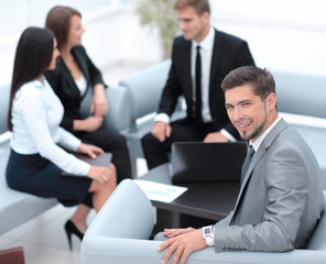 businessman sitting in an office on the background of business team.