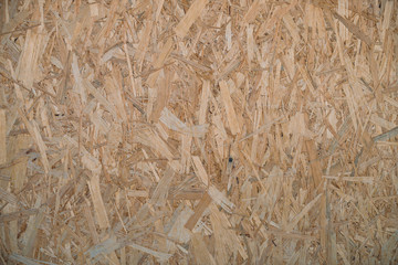 Natural pressed sawdust close-up. Background image of sheet of plywood with fragments of compressed sawdust. Wooden texture template.