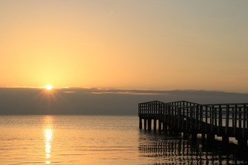 Fototapeta na wymiar malersicher Sonnenaufgang an einem Steg 
