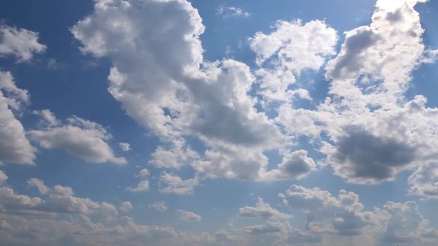 White clouds moving on blue sky. Sun shines through the eddy. Beautiful nature background. Weather concept. Timelapse Close up