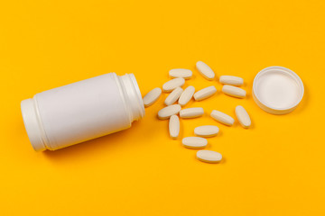 White medical pills on color background