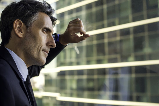 Man looking through window in high rise building