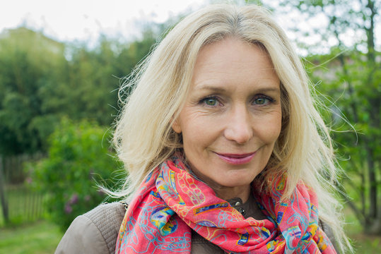 Mature woman smiling outdoors, portrait