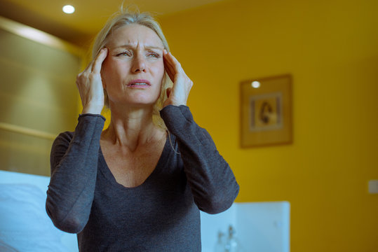 Mature woman massaging temples while suffering a headache