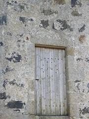 close up of old wooden door in stone wall