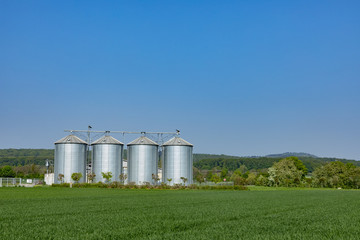Fototapeta na wymiar four silver silos at the field