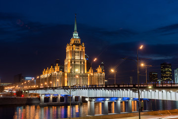 Fototapeta na wymiar Ukraine hotel with illumination near river at night in Moscow, Russia