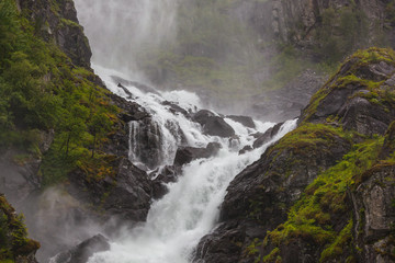 Fototapeta na wymiar Stunning waterfall on the mountain river in Husedalen valley in Hardangervidda national park, Norway
