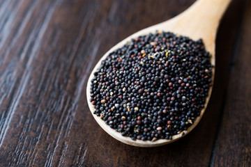 Fototapeta na wymiar Black Mustard Seeds in Wooden Spoon