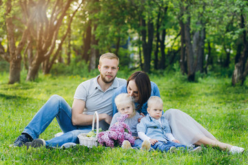 Fototapeta premium Family with two children rest in the summer garden