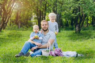 Family with two children rest in the summer garden