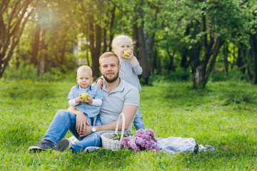 Family with two children rest in the summer garden