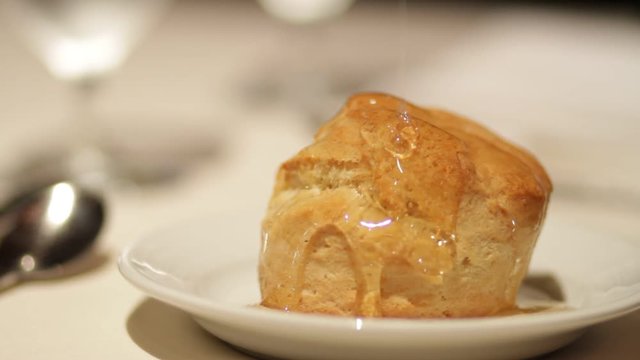 Honey pouring onto a buttermilk biscuit