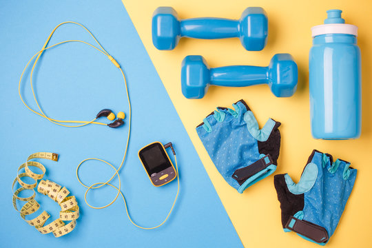 Photo of player, dumbbells, bottle of water, centimeter tape, gloves on blue and yellow background
