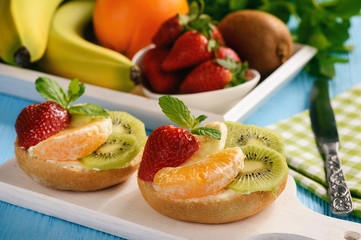 Healthy breakfast fruits and ricotta sandwiches- with strawberries, kiwi and orange.