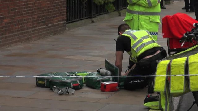 UK May 2012 - A Paramedic Sorts Bags Of Equipment At A Crime Scene.