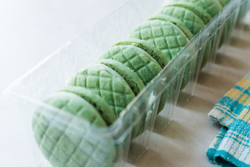 Cream Filled Green Round Lime Cookies / Macarons in Plastic Container.