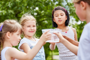 Gruppe Kinder beim Wasser trinken im Sommer