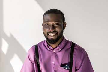 Obraz premium portrait of smiling african american handsome man looking at camera on grey background