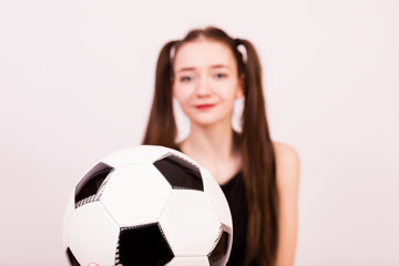 The girl in the dress with the ball for the game of football.