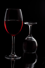 Naklejka na ściany i meble Glass with red wine on a black background