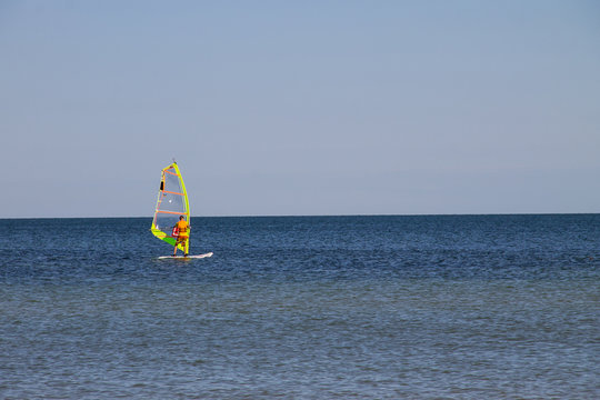 Windsurfing. Surfer exercising in calm sea or ocean.