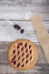 Blackberry and apple pie with fruit on a wooden background 