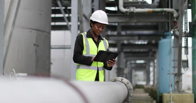 Female industrial worker checking pipeline