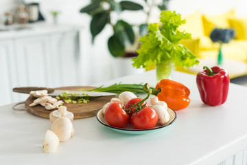 close up view of arranged fresh vegetables and mushrooms on tabletop in kitchen