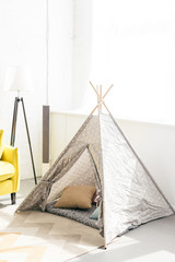 close up view of childish teepee with pillows in room