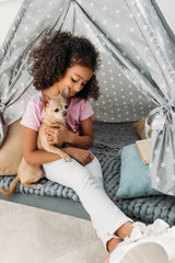 little cute african american kid with chihuahua dog in teepee at home © LIGHTFIELD STUDIOS