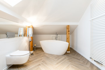 Fototapeta na wymiar White attic bathroom with bathtub