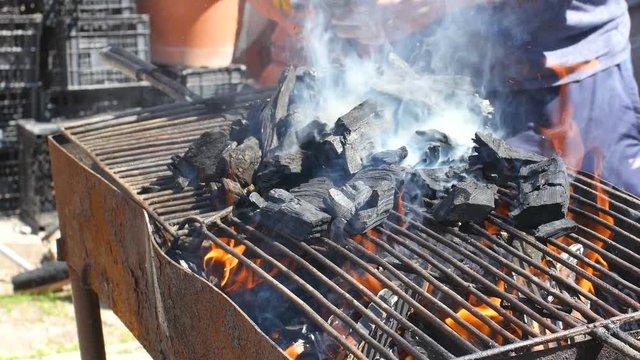 Placing A Bag Of Coal On A Grill