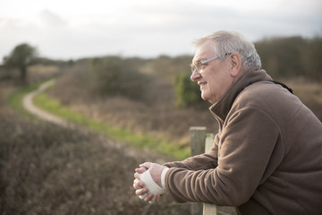 Relaxed mature man outdoors, looking out over a view 