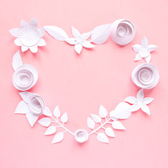 White paper flowers, lined in the shape of a heart on pink background. Cut from paper.
